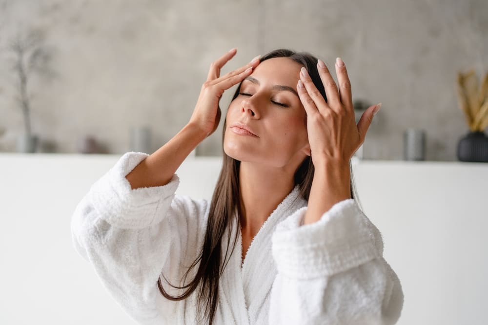 Woman performing skincare ritual on her face